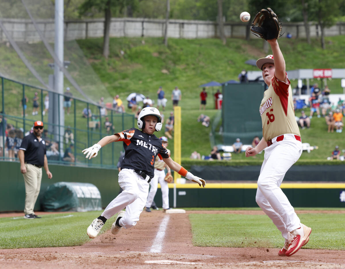 Rhode Island's Brady McShane (3) beats a throw and scores before Henderson All-Stars pitcher Lo ...