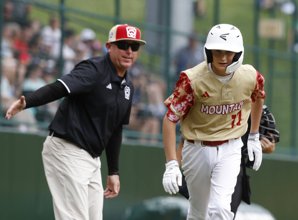 The Henderson All-Stars centerfielder Jaxson McMullen runs past assistant coach Arlie Daniel af ...