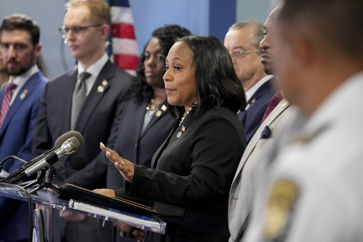 Fulton County District Attorney Fani Willis, center, speaks in the Fulton County Government Cen ...