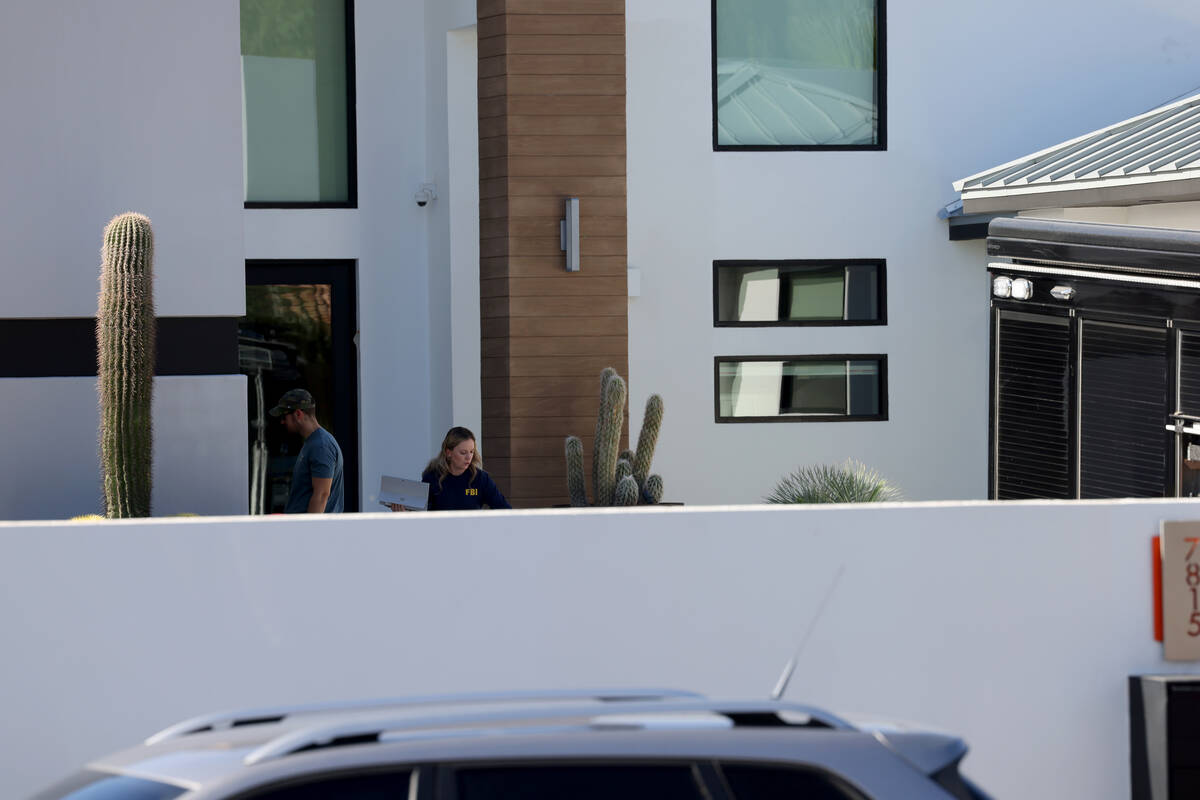 FBI personnel investigate at a home on the corner of West La Madre Way and Conough Lane in Las ...