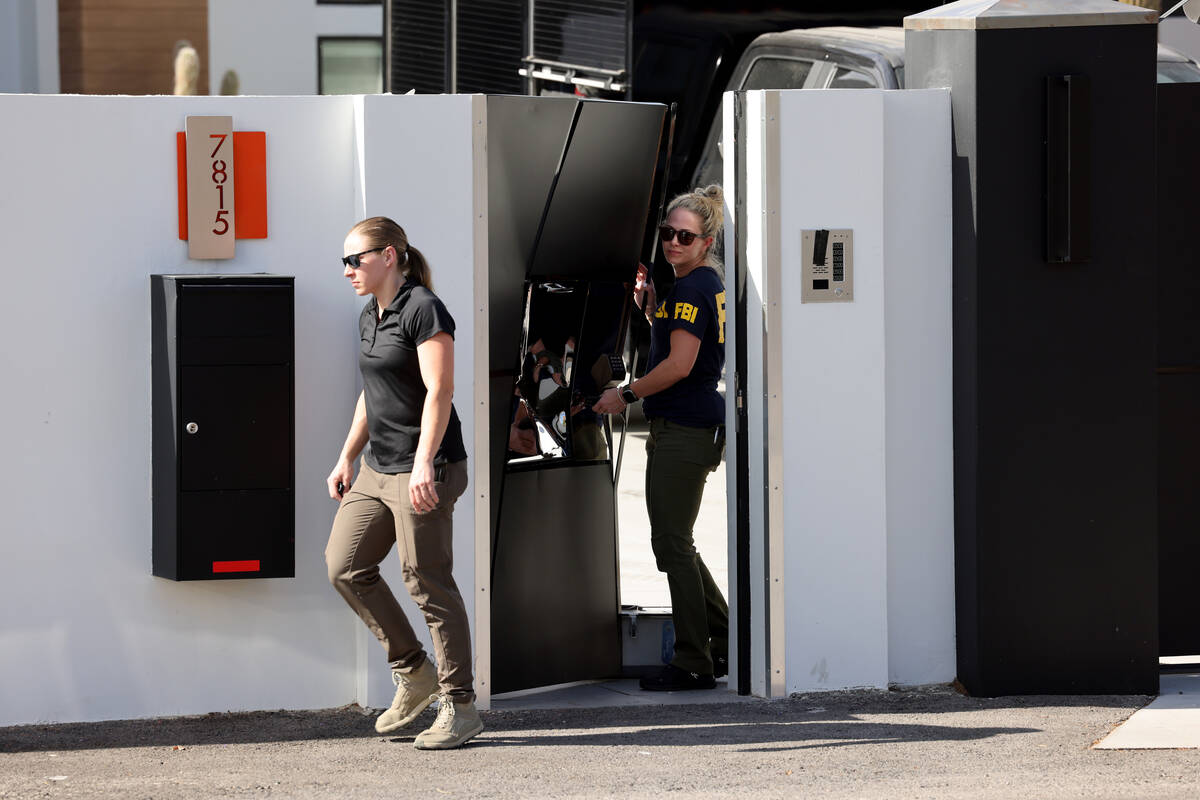 FBI personnel investigate at a home on the corner of West La Madre Way and Conough Lane in Las ...