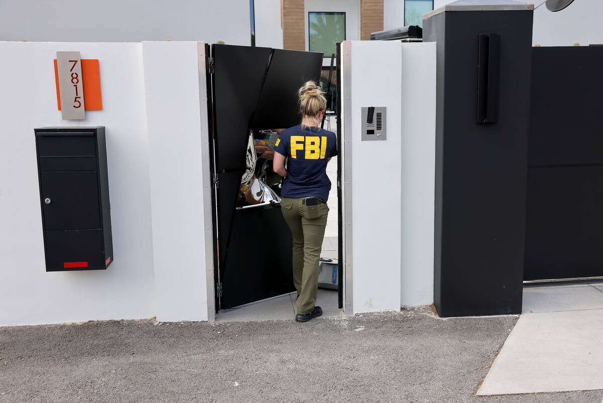 FBI personnel investigate at a home on the corner of West La Madre Way and Conough Lane in Las ...