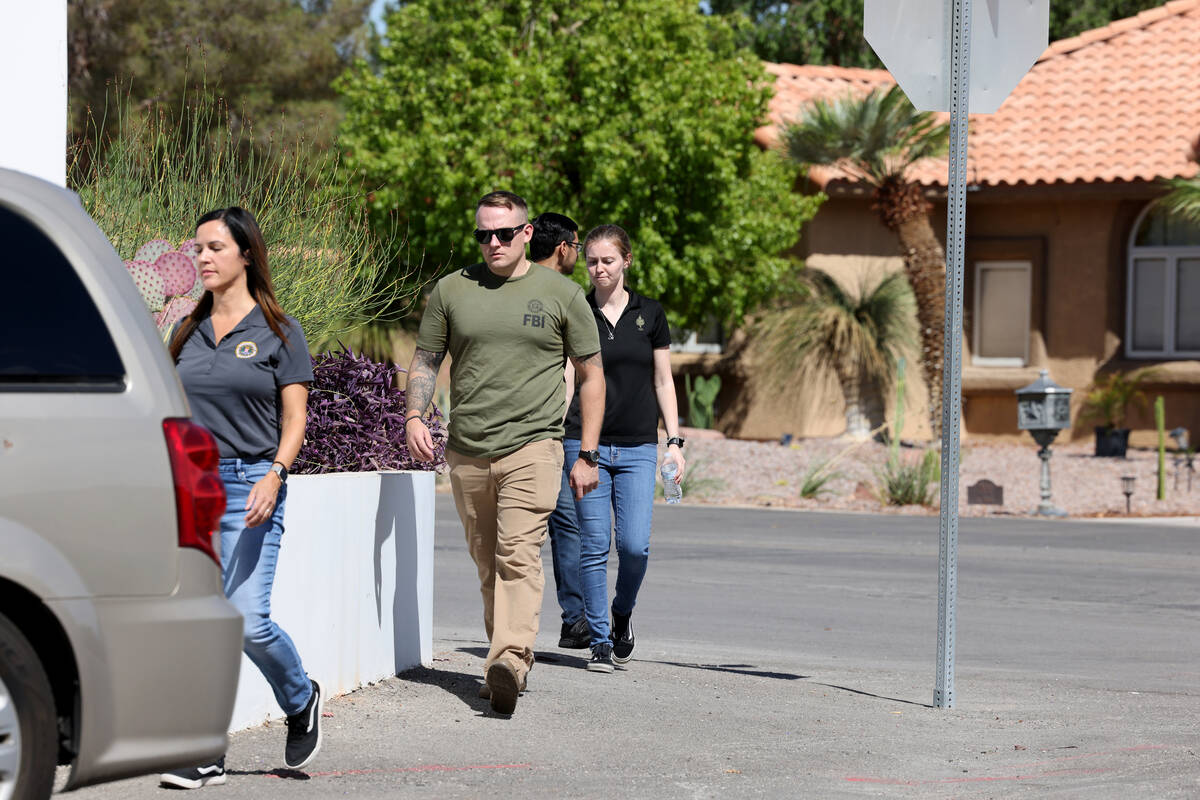 FBI personnel investigate at a home on the corner of West La Madre Way and Conough Lane in Las ...