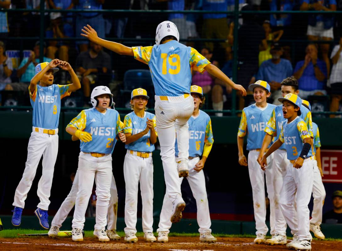 El Segundo, California All-Stars first baseman Louis Lappe congratulated by his teammates after ...