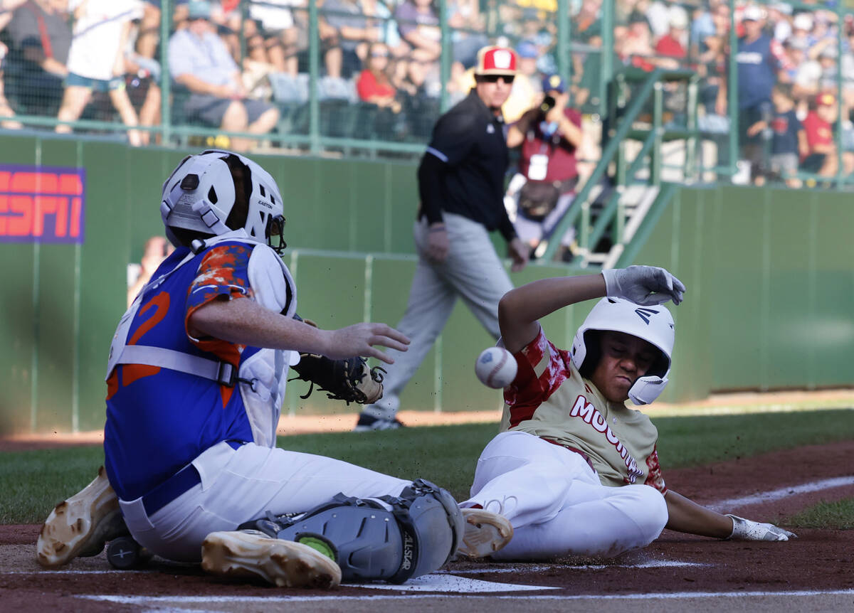 The Henderson All-Stars pitcher David Edwards (15) avoids the tag from New Albany, Ohio, catche ...