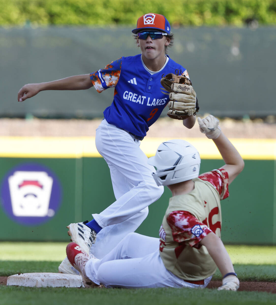 The Henderson All-Stars third baseman Logan Levasseur beats a throw and slides safe at second a ...