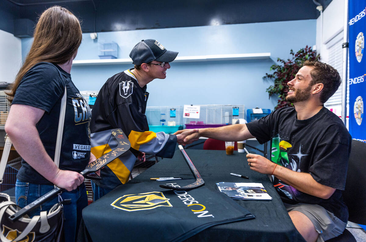 Golden Knights forward Gage Quinney, right, talks with fans Eric Hard and Heather Payrot during ...