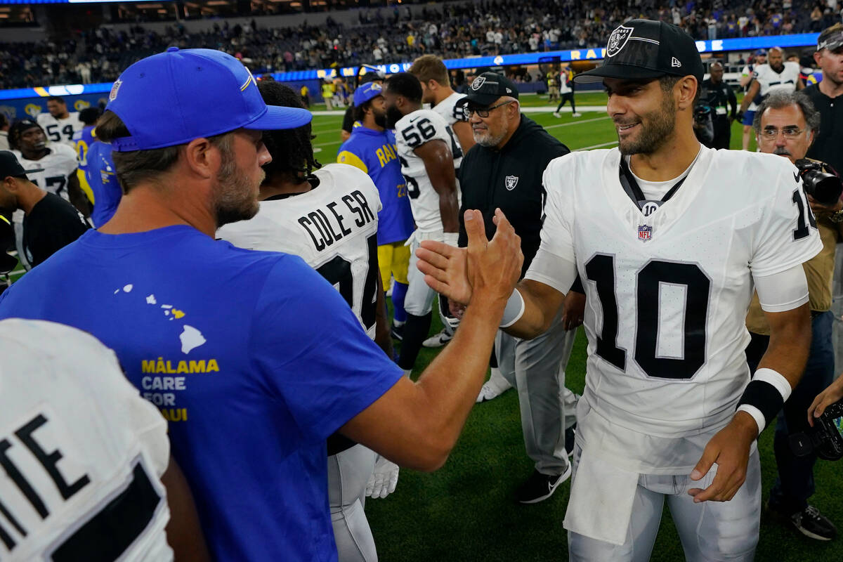 Las Vegas Raiders quarterback Jimmy Garoppolo, right, shakes hands with Los Angeles Rams quarte ...