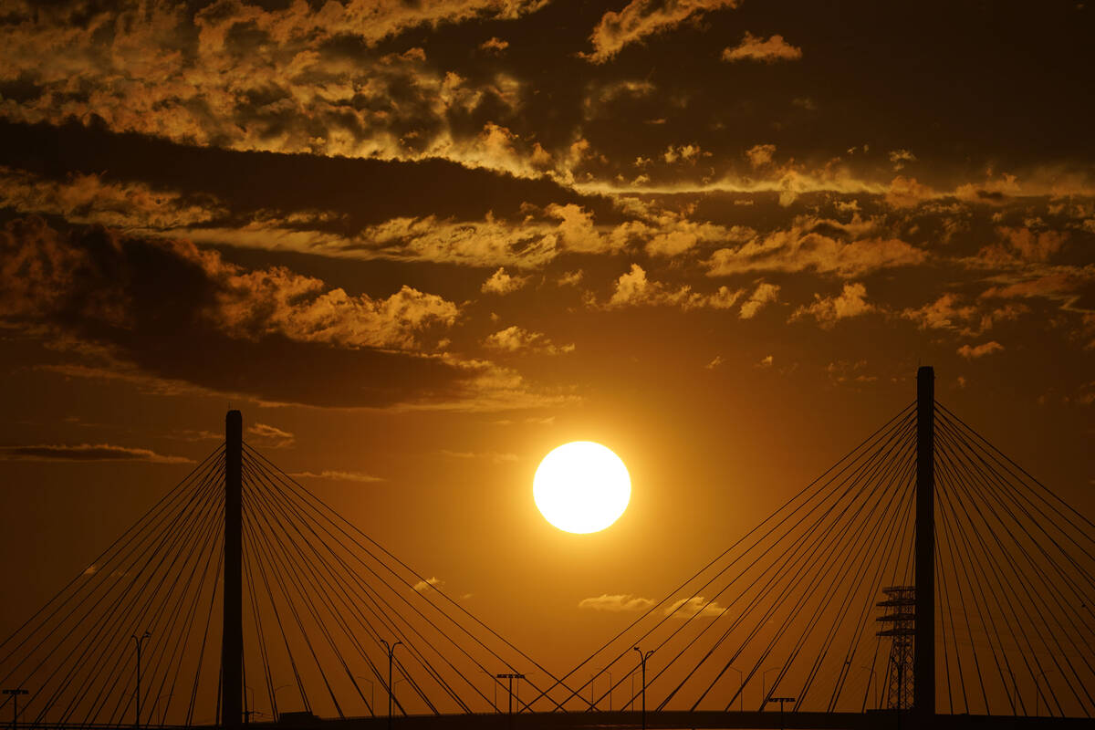 The sun sets over the Long Beach International Gateway ahead of Hurricane Hilary in Long Beach, ...