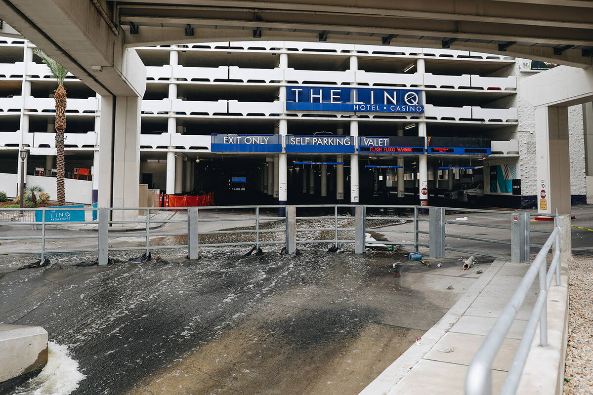 Water flows into a flood channel from The Linq parking garage on Sunday, Aug. 20, 2023, in Las ...