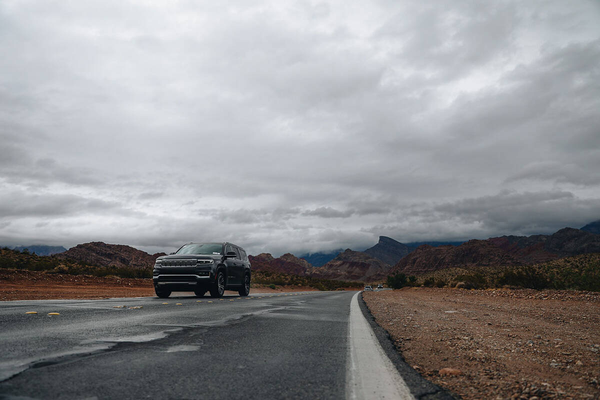 A car drives away from storms developed by Hurricane Hilary in the Red Rock National Conservati ...