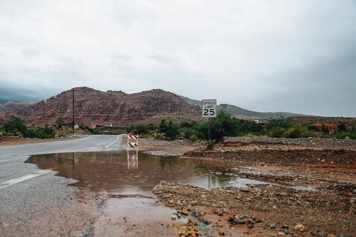 Water from recent flooding pools over onto the street in the Red Rock National Conservation Are ...