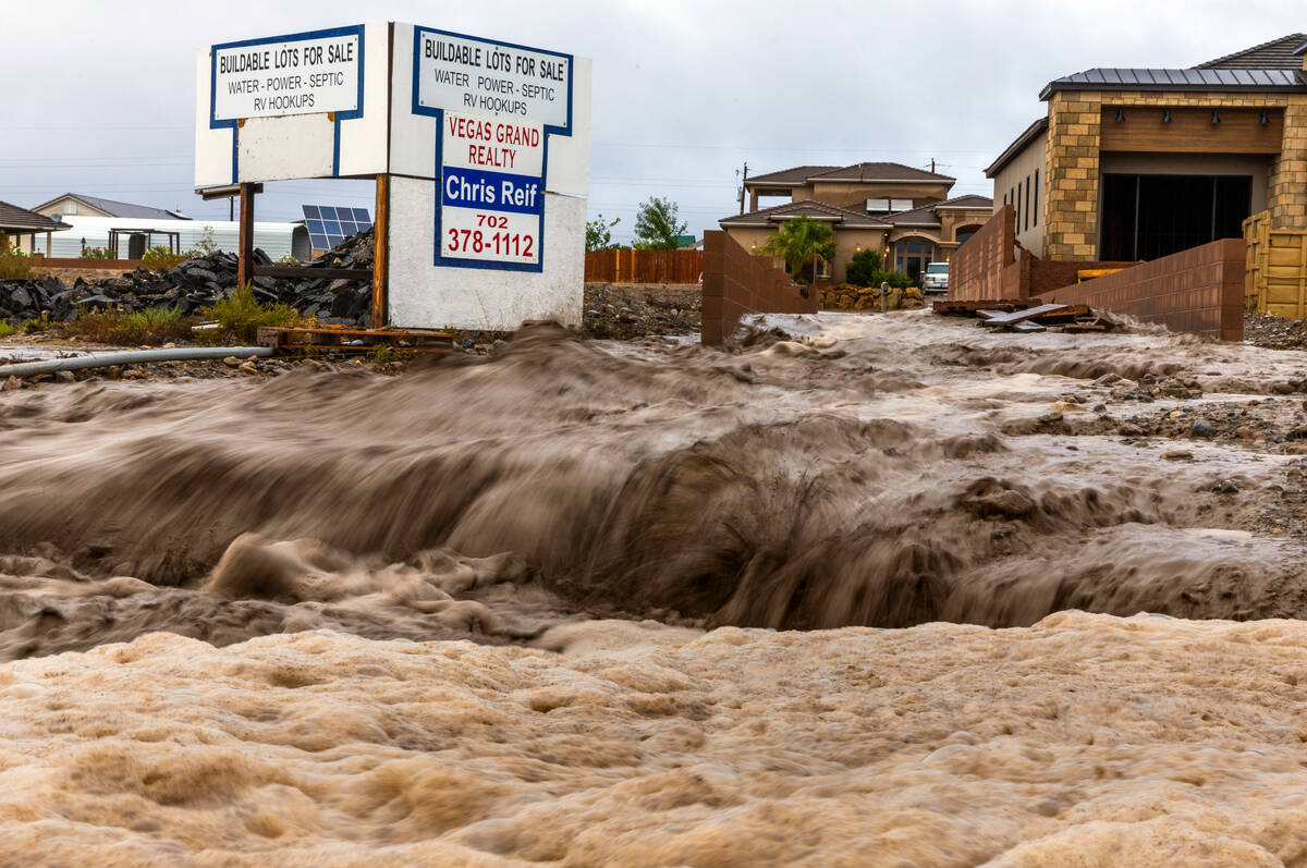 Flood waters flow heavy down the street onto Highway 160 as the remnants of tropical storm Hila ...