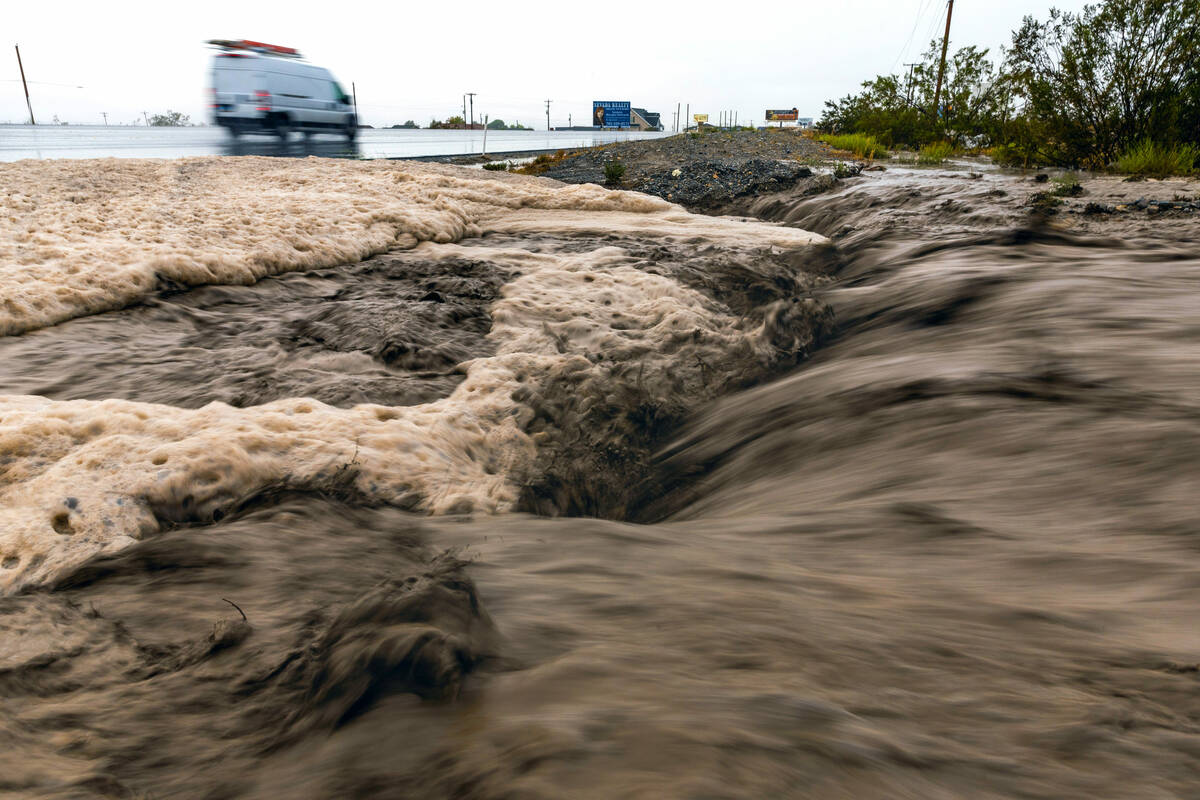 Flood waters flow heavy down the street onto Highway 160 as the remnants of tropical storm Hila ...