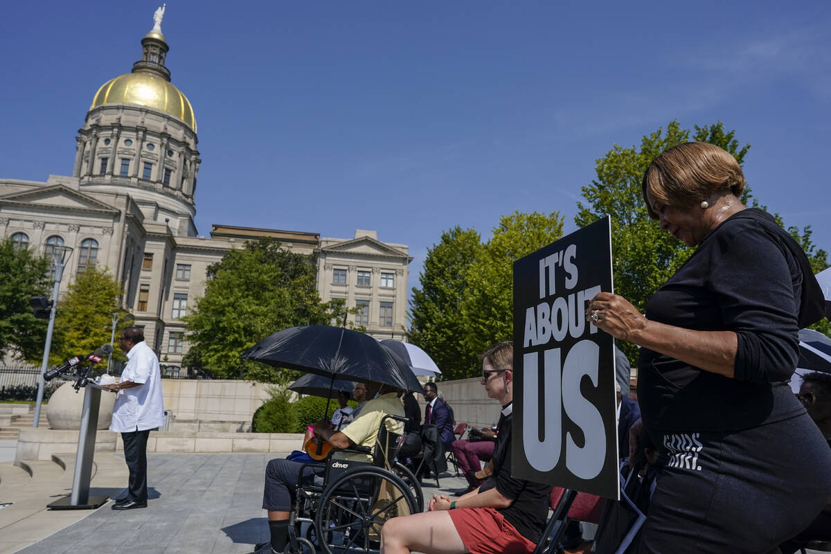 A woman prays in support of Fulton County District Attorney Fani Willis and others inside the c ...