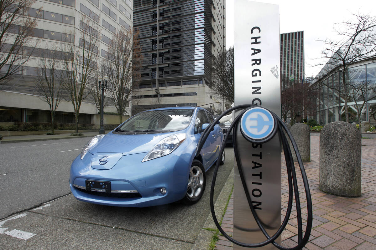 A car is parked by an electric charging station in downtown Portland, Ore., March 31, 2011. (AP ...