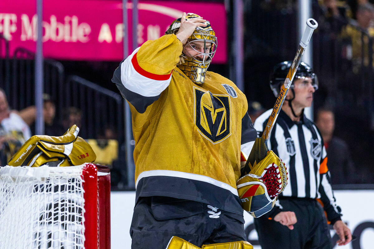 Golden Knights goaltender Adin Hill (33) adjust his helmet after more contact at the net by the ...