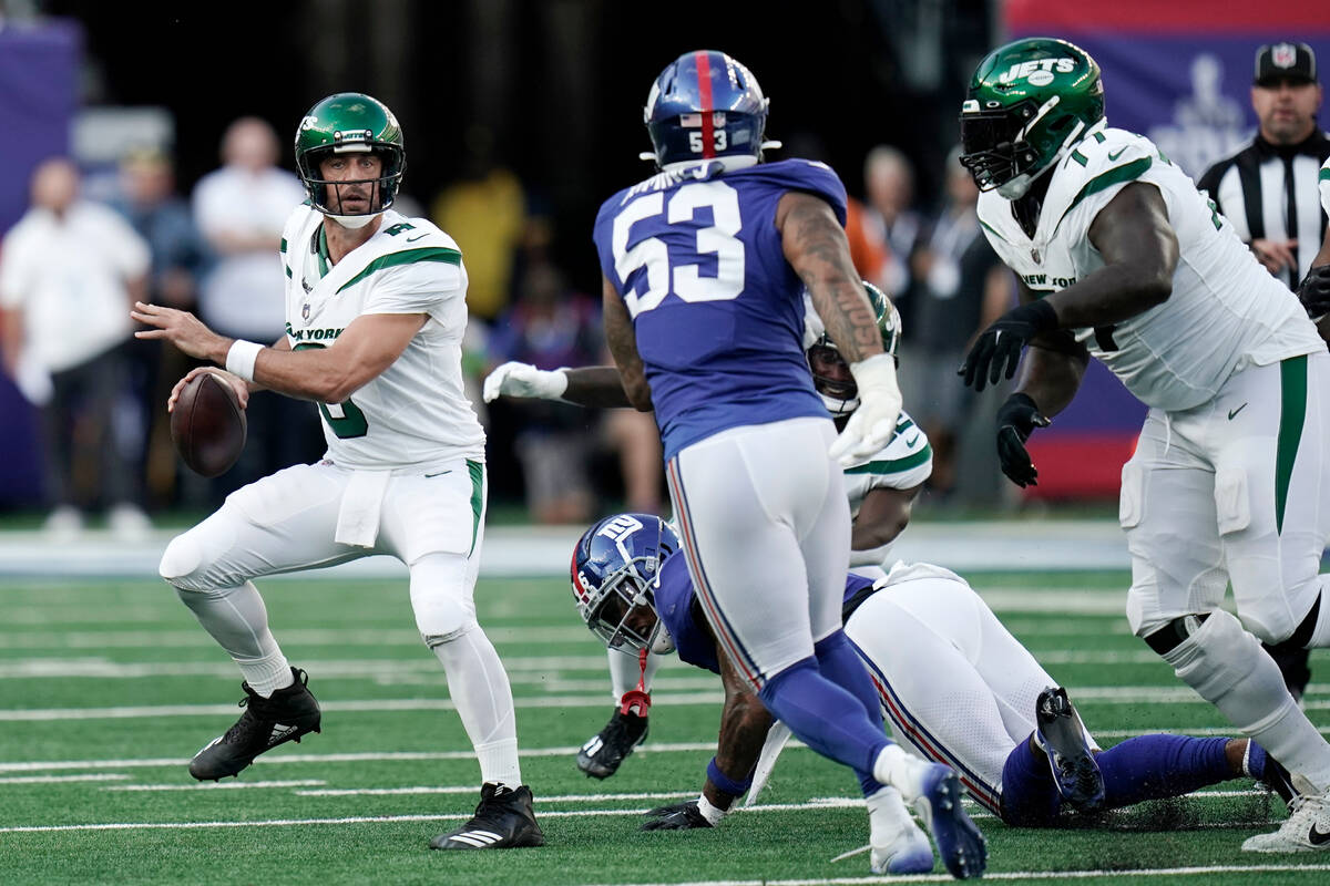 New York Jets quarterback Aaron Rodgers (8) drops back to pass during an NFL football game agai ...