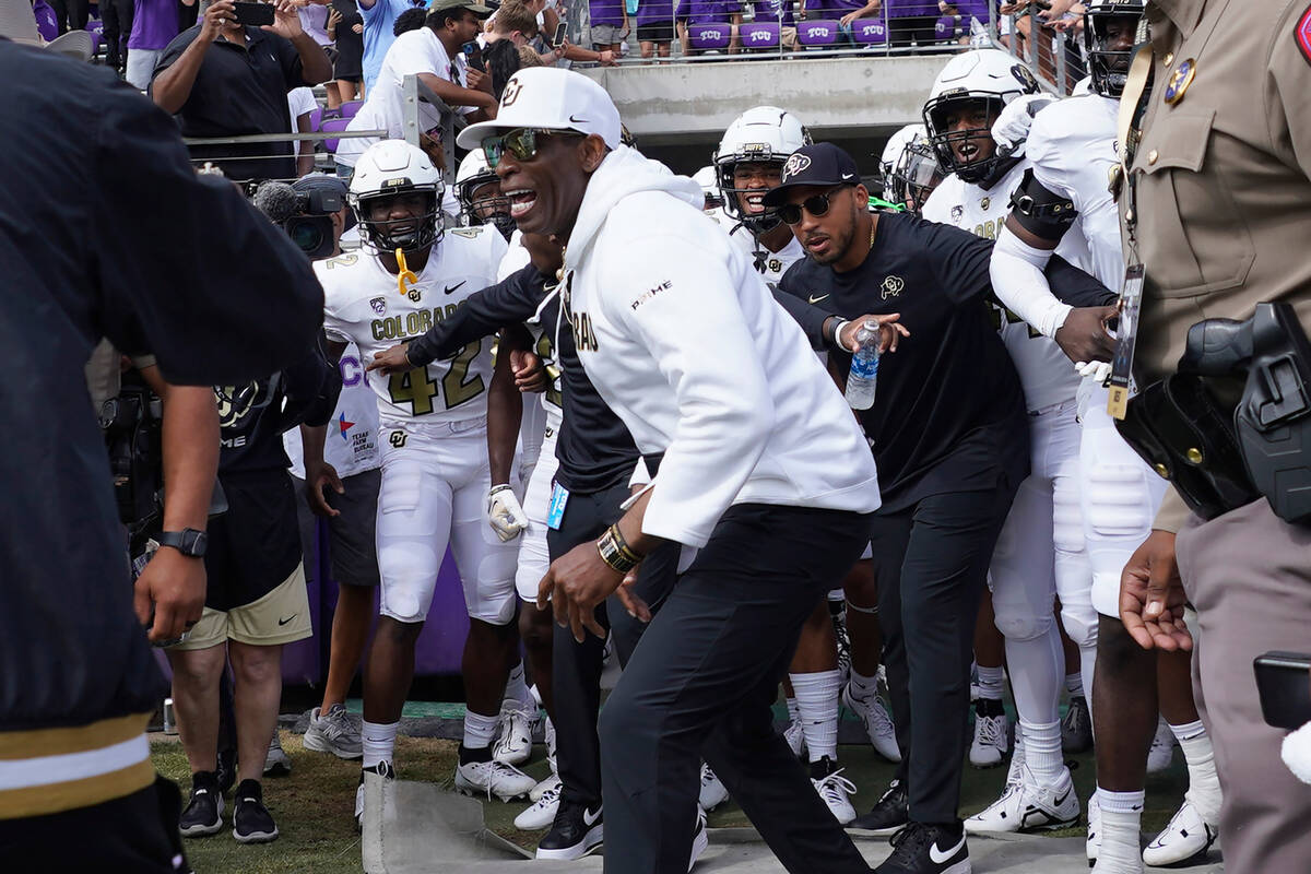 Colorado head coach Deion Sanders runs onto the field with his team for a an NCAA college footb ...