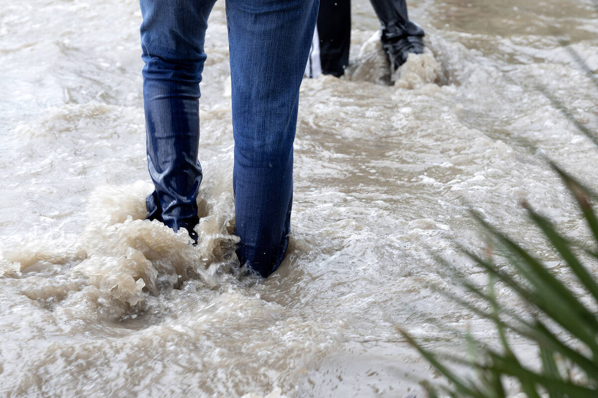 Pedestrians walk through flooded sidewalks on South Eastern Avenue on Friday, Sept. 1, 2023, in ...