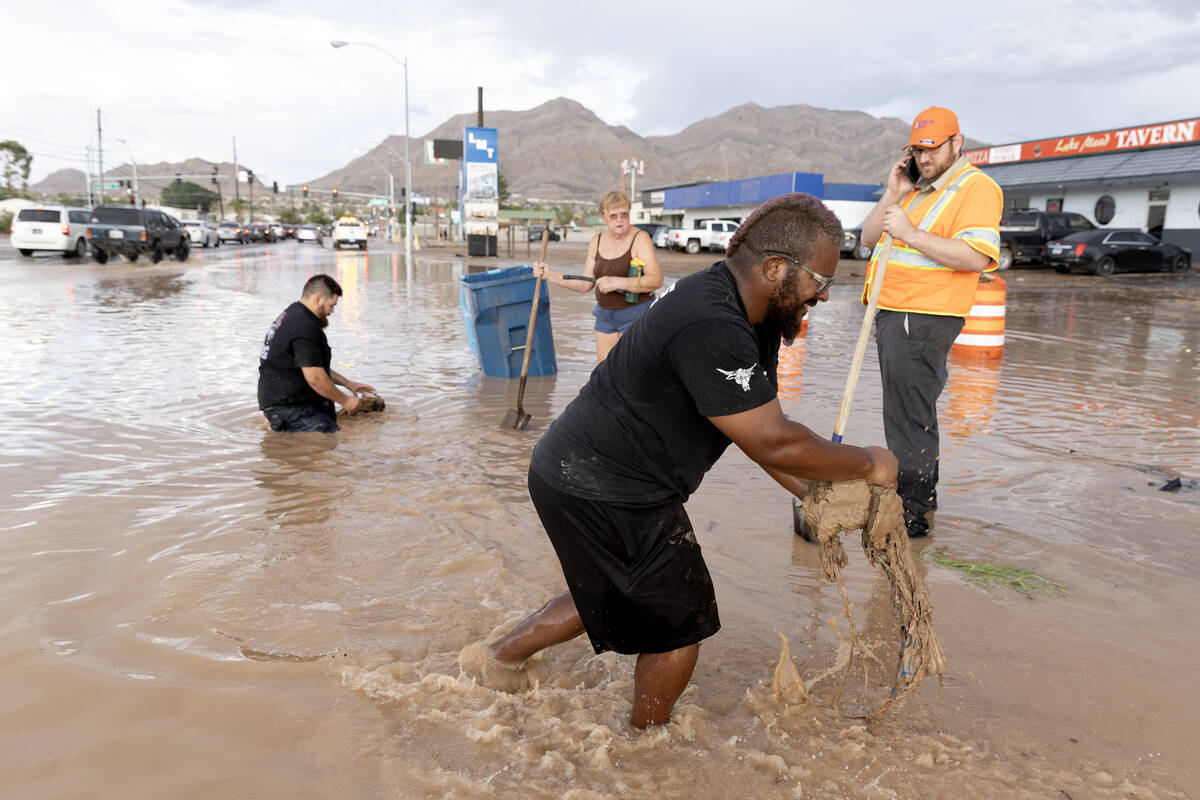 Adrian Green removes debris from storm drains with his neighbors and an NDOT employee on Saturd ...