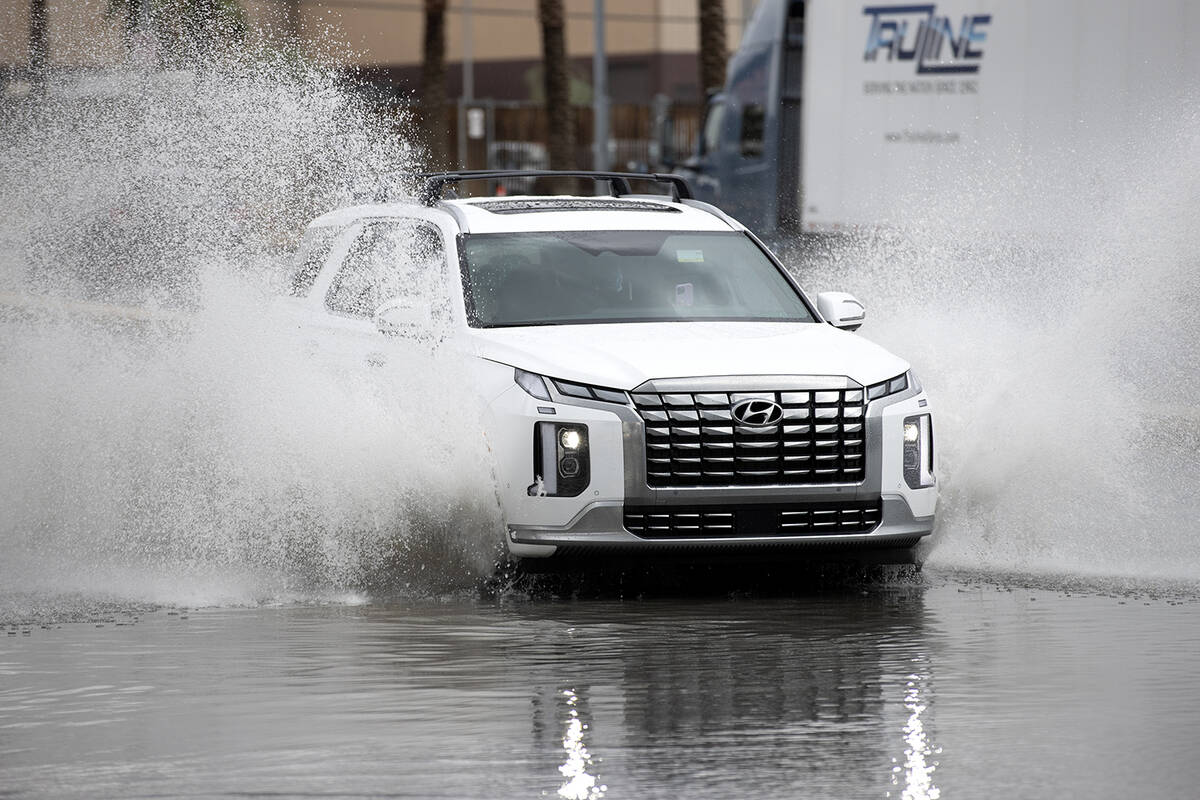 A vehicle passes through flood waters at West Russell Road and Polaris Avenue on Saturday, Sept ...