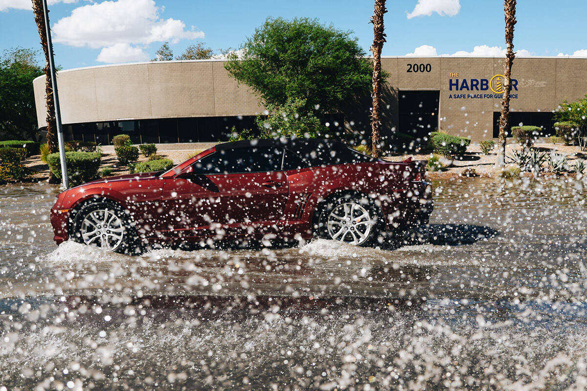 A car drives through residual flooding from recent rainfall on North Mojave Road on Sunday, Sep ...