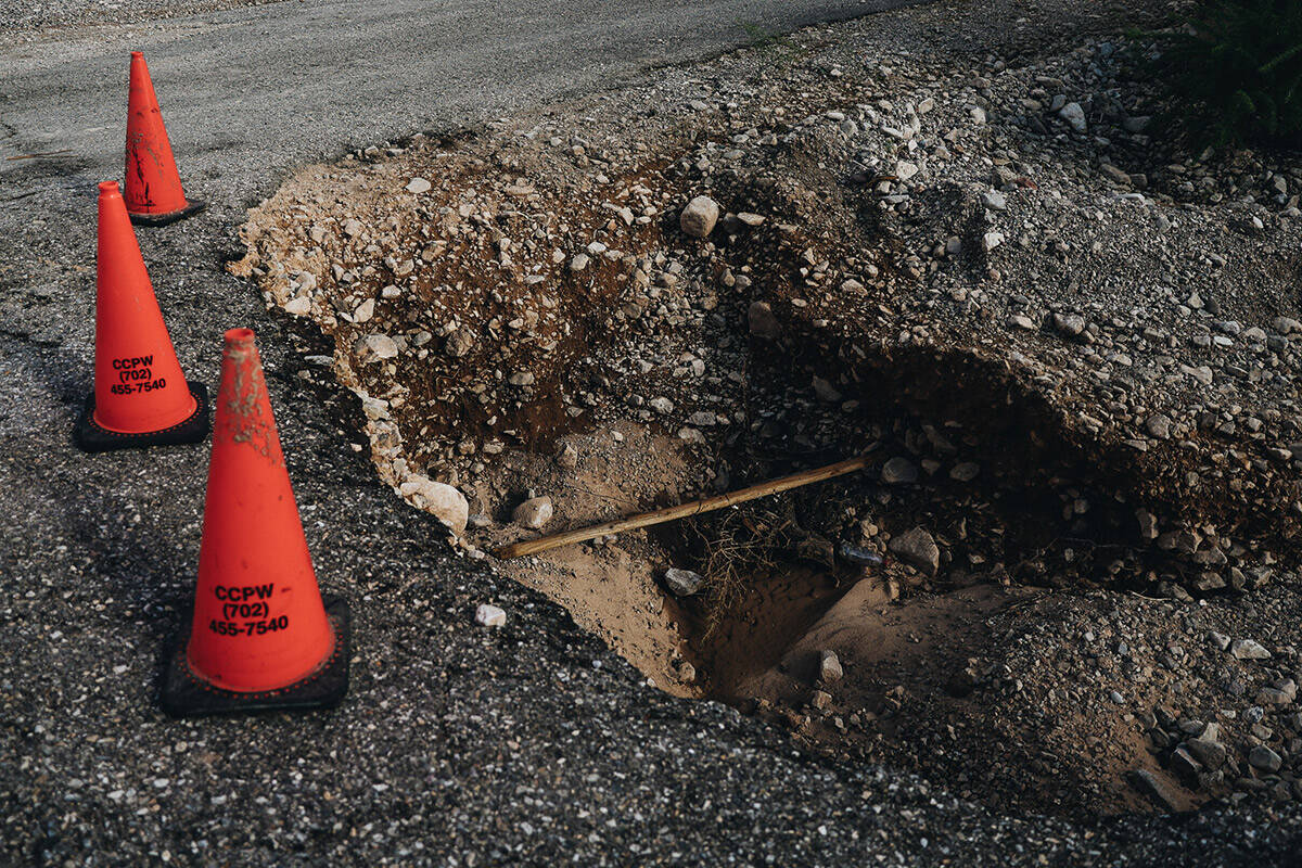 Damage to a road from flooding is seen in a neighborhood near Frenchman Mountain on Sunday, Sep ...