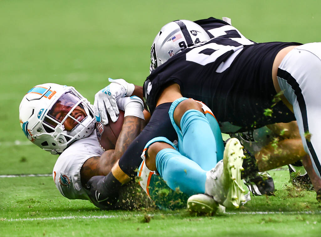 Raiders defensive end Carl Nassib (94) takes down Miami Dolphins running back Myles Gaskin duri ...