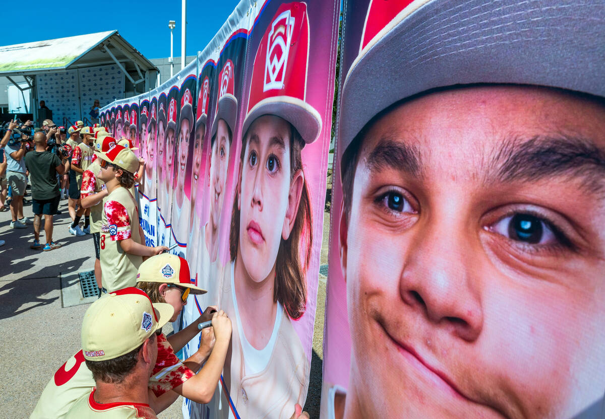 Henderson Little League team player Cruz Lester (3) with teammates and coaches sign their portr ...