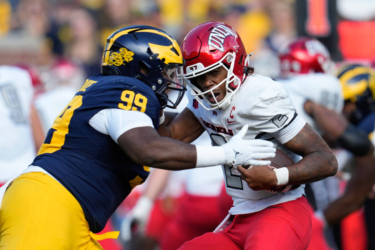 Michigan defensive lineman Cam Goode (99) tackles UNLV quarterback Doug Brumfield (2) in the fi ...