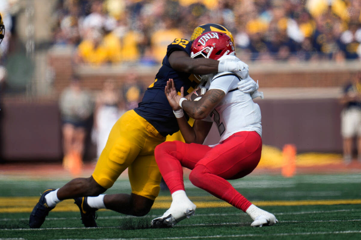 Michigan defensive end Jaylen Harrell (32) sacks UNLV quarterback Doug Brumfield (2) in the fir ...