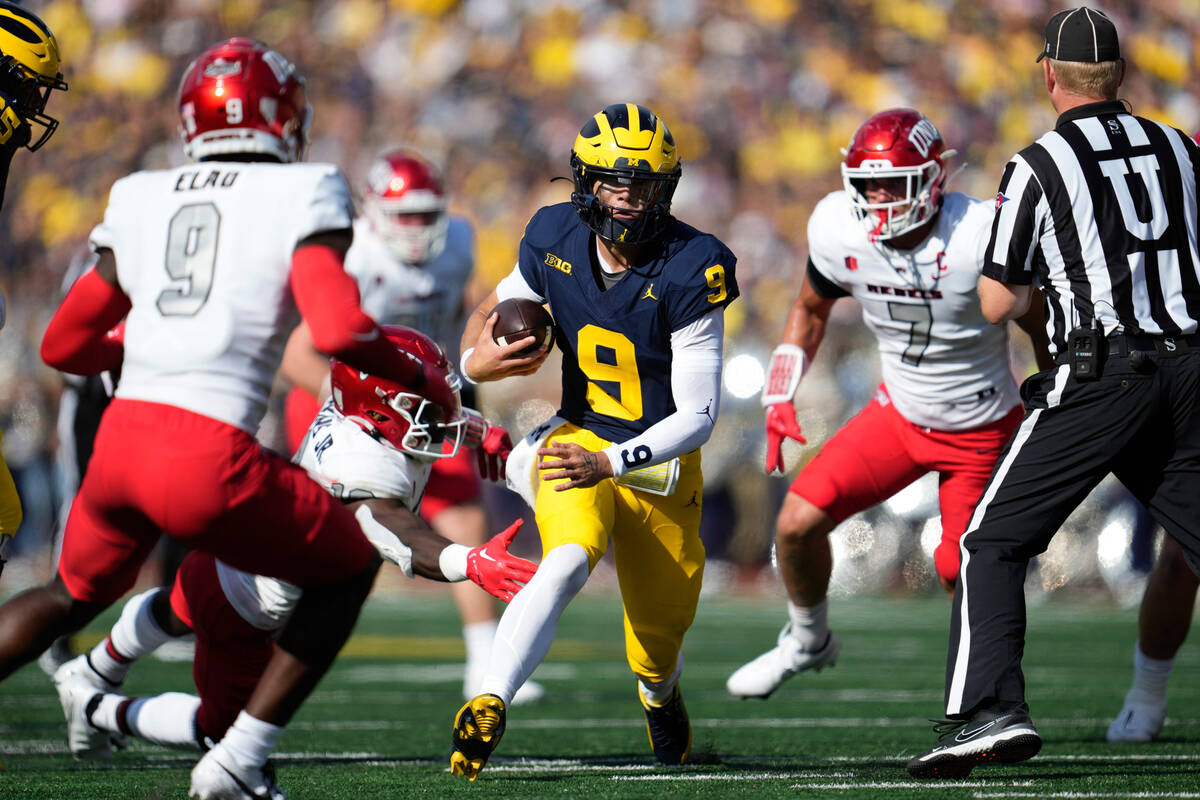 Michigan quarterback J.J. McCarthy (9) runs the ball against UNLV in the first half of an NCAA ...