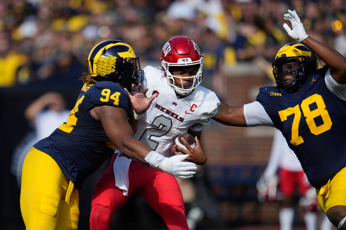 UNLV quarterback Doug Brumfield (2) is sacked by Michigan defensive linemen Kris Jenkins (94) a ...