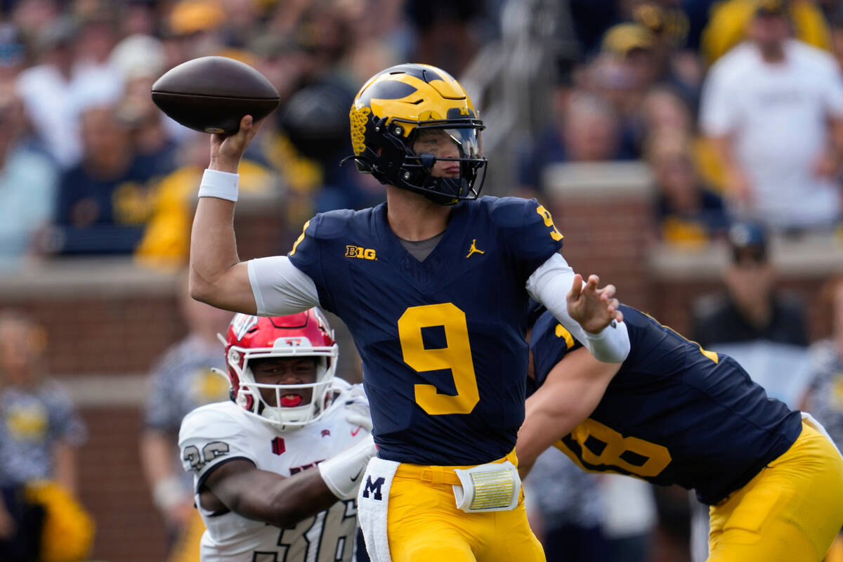 Michigan quarterback J.J. McCarthy (9) throws against UNLV in the first half of an NCAA college ...