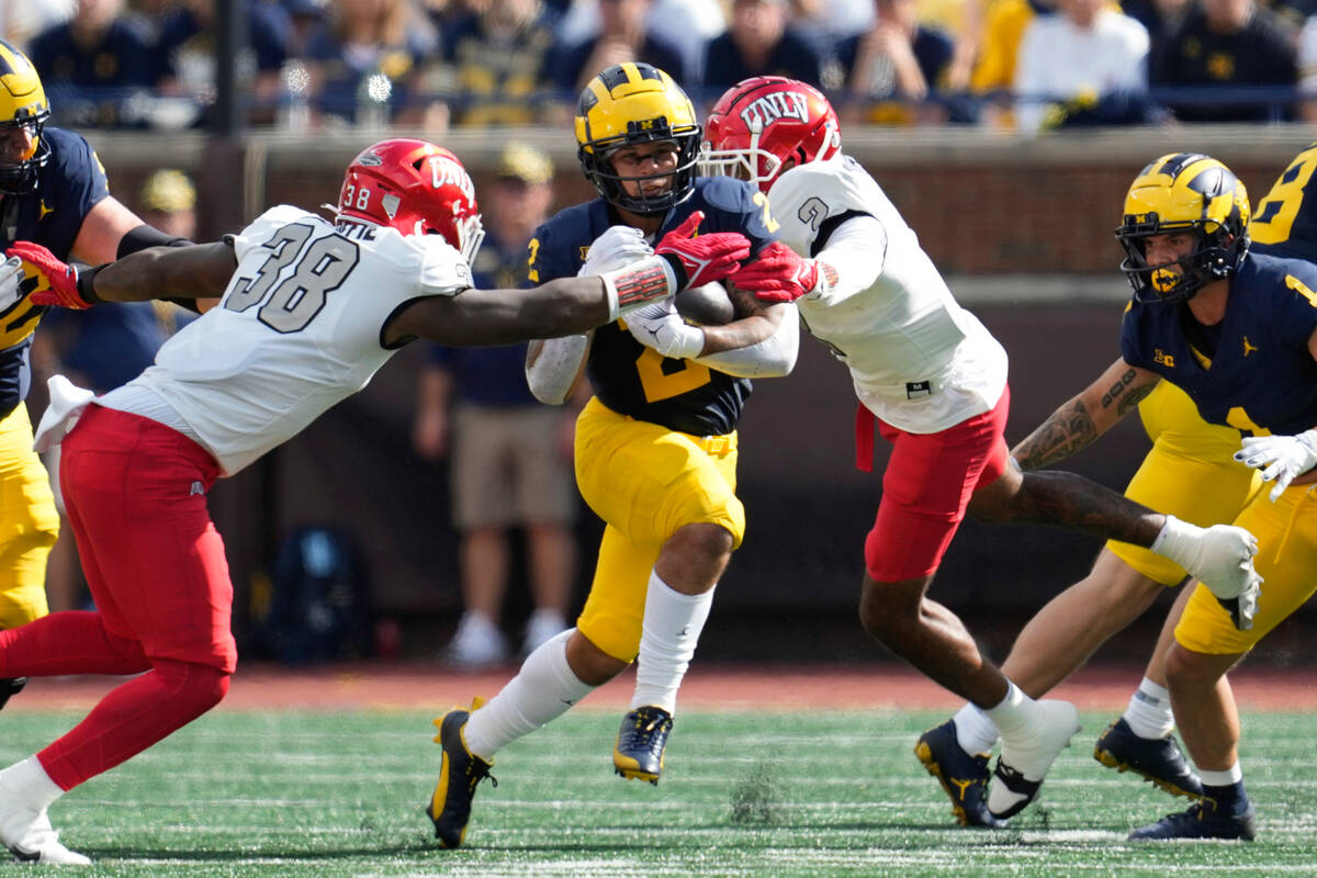 Michigan running back Blake Corum (2) runs against UNLV linebacker Marsel McDuffie (38) in the ...