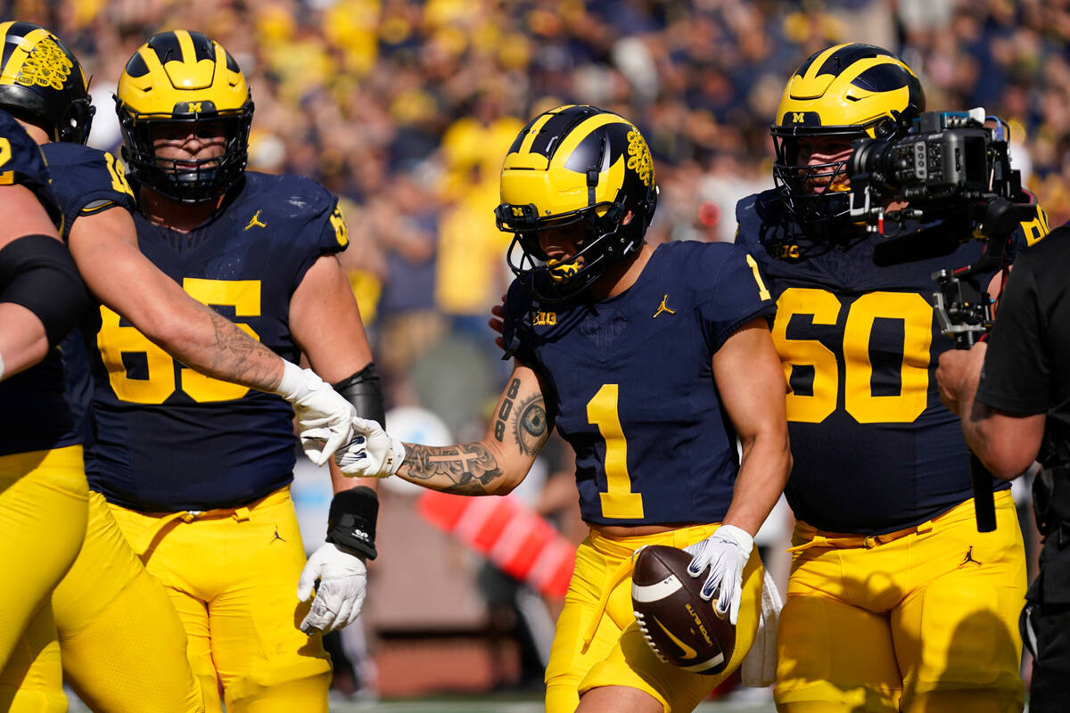 Michigan wide receiver Roman Wilson (1) celebrates his touchdown reception against UNLV in the ...