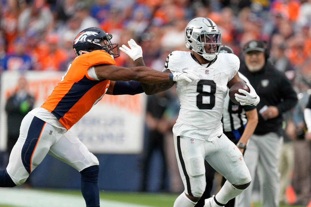 Las Vegas Raiders running back Josh Jacobs (8) gets tackled by Denver Broncos linebacker Jonath ...