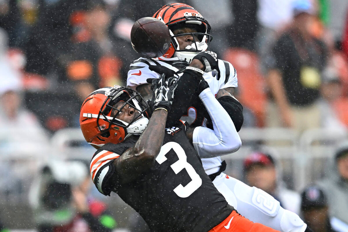 Cincinnati Bengals cornerback Cam Taylor-Britt, right, breaks up a pass intended for Cleveland ...