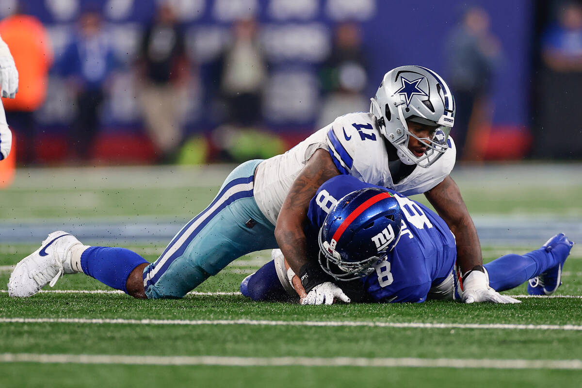 Dallas Cowboys' Micah Parsons (11), top, tackles New York Giants quarterback Daniel Jones durin ...