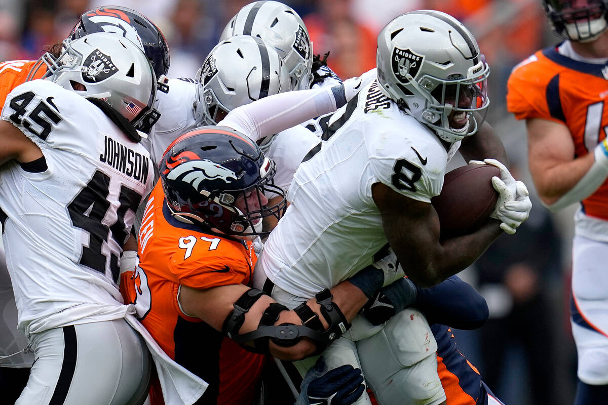 Las Vegas Raiders running back Josh Jacobs (8) is hit by Denver Broncos defensive end Zach Alle ...