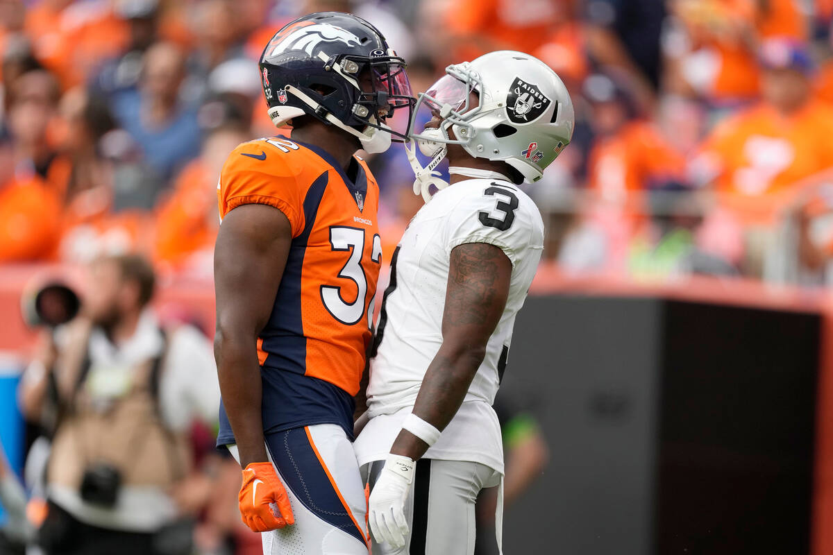 Denver Broncos safety Delarrin Turner-Yell, left, and Las Vegas Raiders wide receiver DeAndre C ...