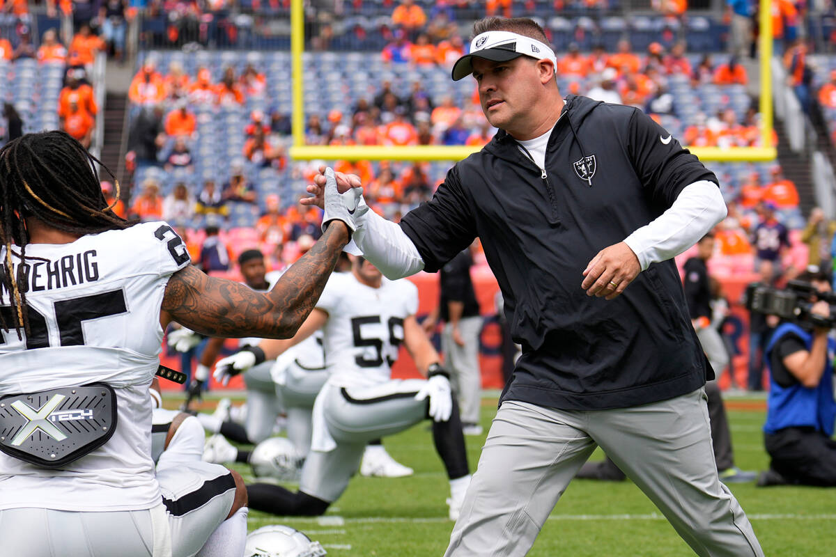 Las Vegas Raiders head coach Josh McDaniels talks with players prior to an NFL football game ag ...