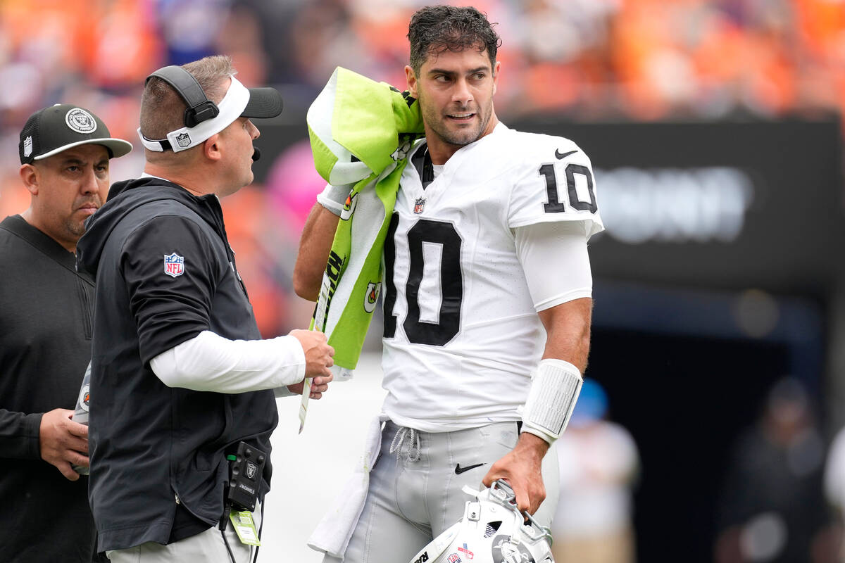 Las Vegas Raiders quarterback Jimmy Garoppolo (10) talks with Raiders head coach Josh McDaniels ...