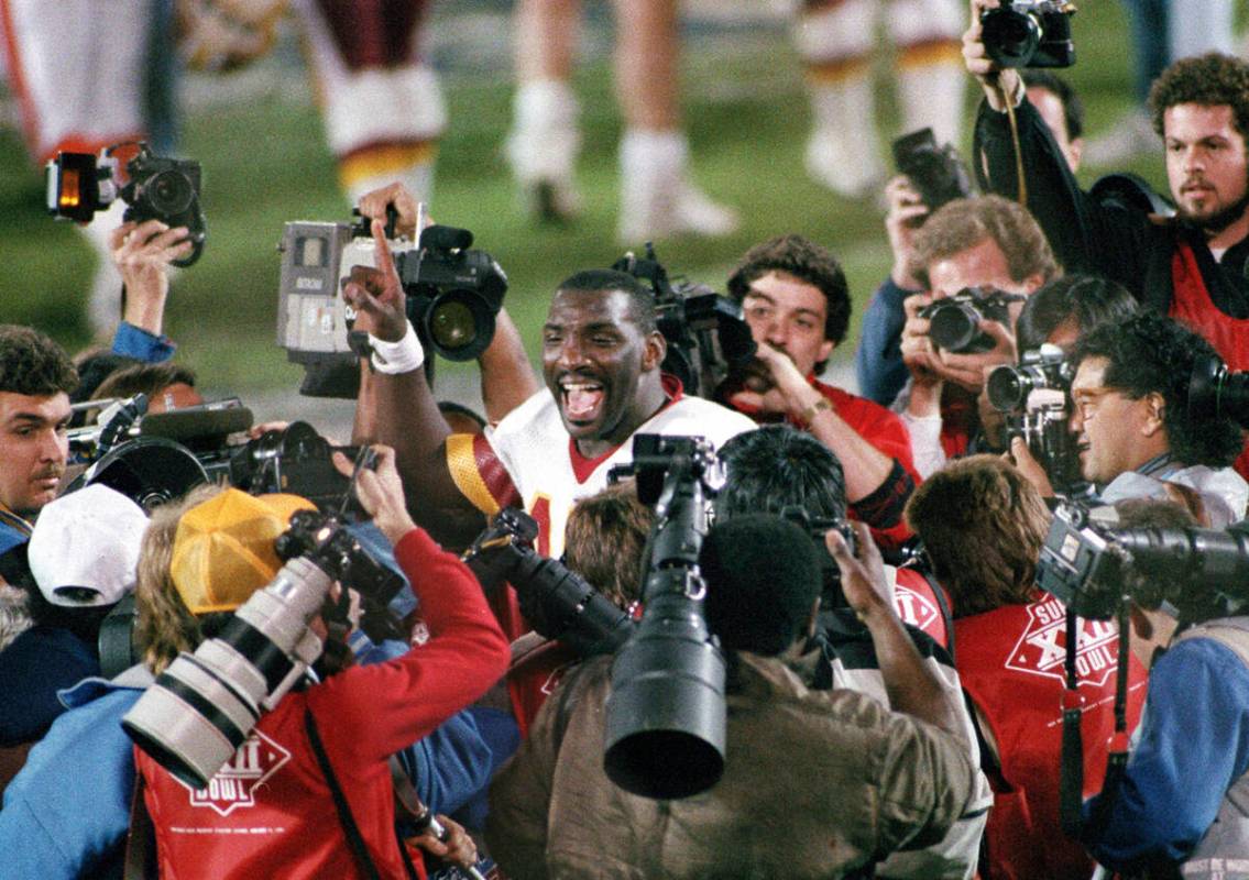 FILE - Washington Redskins quarterback Doug Williams is surrounded by members of the media afte ...