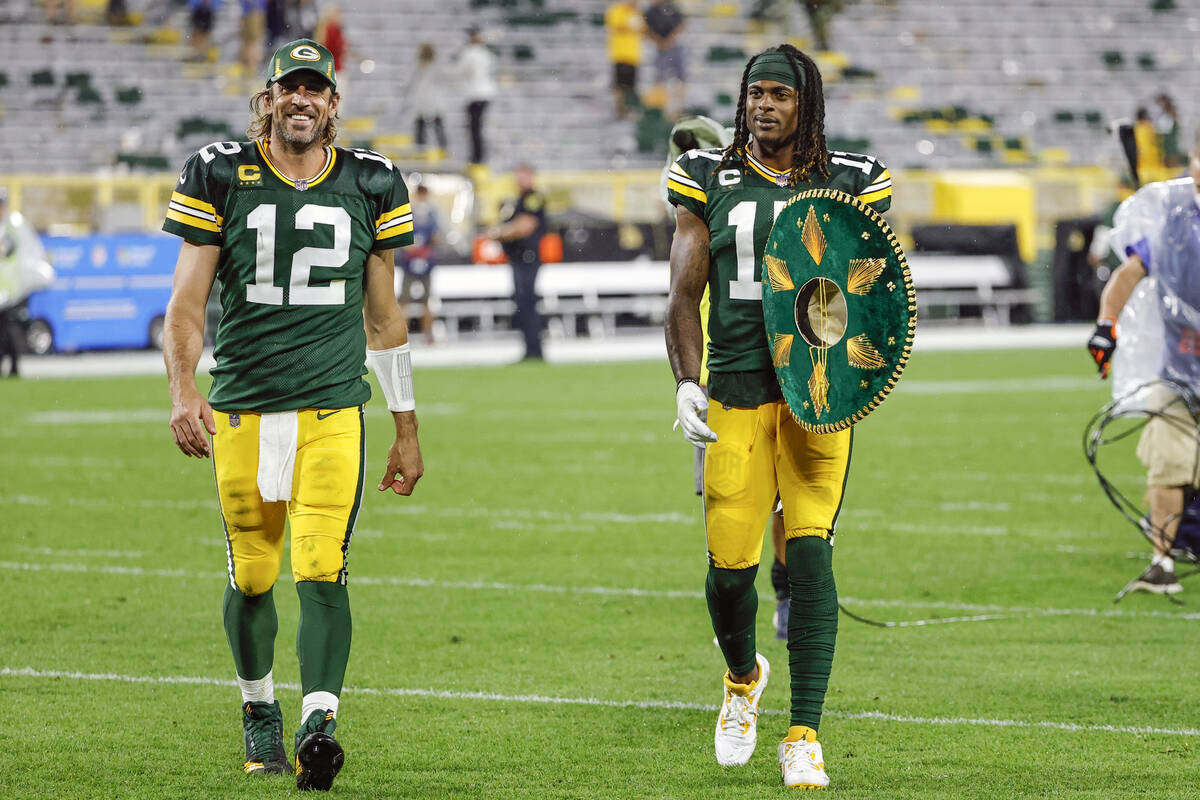 Green Bay Packers quarterback Aaron Rodgers (12) and wide receiver Davante Adams (17) walk off ...