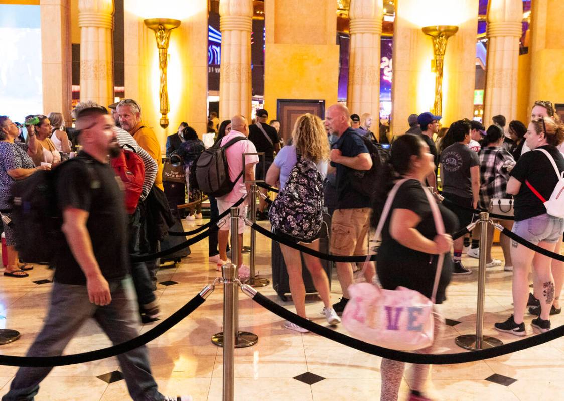 Hotel guests wait in line as they check in at Luxor hotel-casino, on Thursday, Sept. 14, 2023, ...