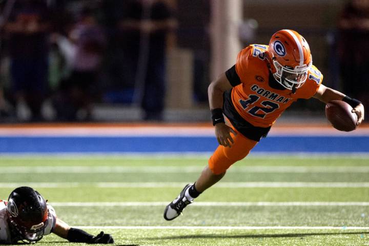 Bishop Gorman quarterback Micah Alejado (12) dives into the sidelines on a carry after Centenni ...