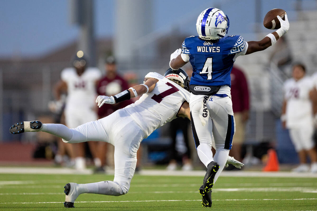 Basic cornerback Chris Smith (4) catches an interception over Faith Lutheran running back Mason ...