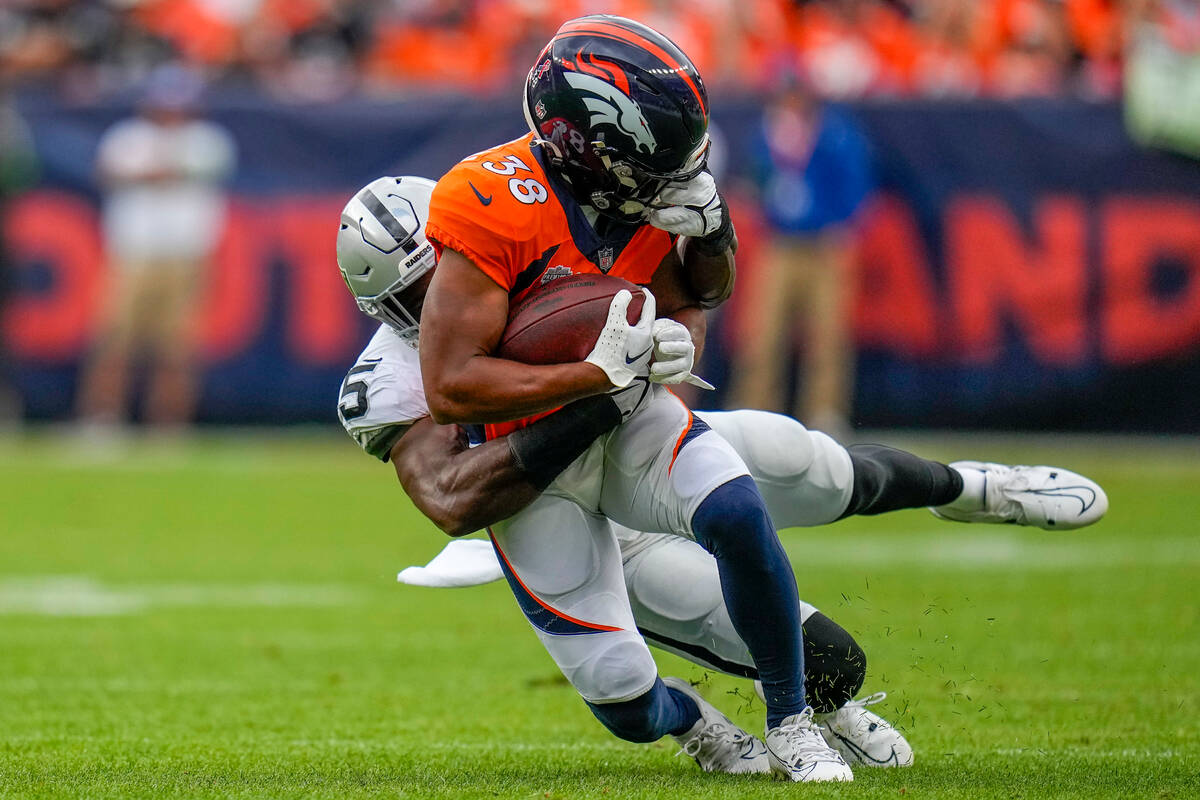 Denver Broncos running back Jaleel McLaughlin (38) is tackled by Las Vegas Raiders linebacker D ...